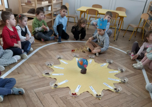 urodzinowe słoneczko - chłopiec nawleka koraliki na sznurek