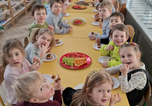 dzieci siedzą przy stole urodzinowym