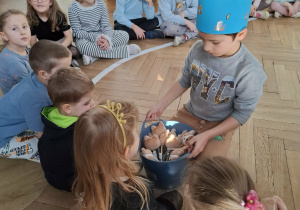 chłopiec w koronie wręcza upominki