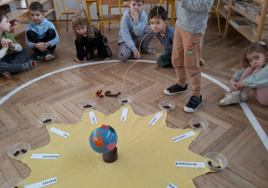 urodzinowe słoneczko - chłopiec nawleka koraliki na sznurek