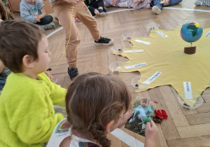 urodzinowe słoneczko - chłopiec nawleka koraliki na sznurek, dzieczynka ogląda zdjęcie