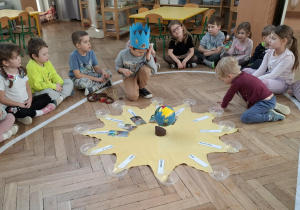 urodzinowe słoneczko - chłopiec nawleka koraliki na sznurek