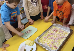 Dzieci przygotowują wspólnie pizzę