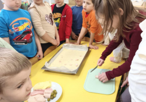 Dzieci przygotowują wspólnie pizzę