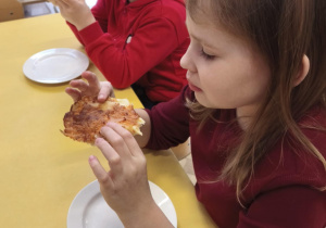 Dzieci jedzą pizzę