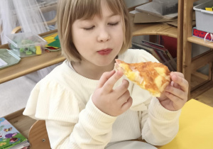 Dzieci jedzą pizzę