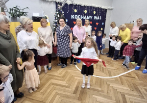 Na zdjęciu widzimy dziadków bawiących się ze swoimi wnukami w zabawy ruchowe.