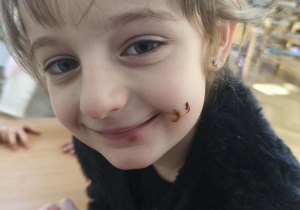 Na zdjęciu widzimy dziewczynkę, która ubrudzona jest na buzi nutellą. Na pewno naleśnik jej smakował :-)