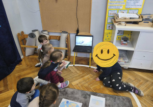 Na zdjęciu widzimy dzieci, które oglądają film o niedźwiedziu polarnym.