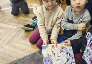 Na zdjęciu widzimy dzieci, które poszukują w książkach wiadomości i ilustracji o niedźwiedziu polarnym.
