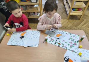 Na zdjęciu widzimy dwójkę dzieci, którzy wykonują pracę plastyczną.