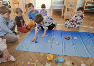 dzieci układają elementy kosmosu