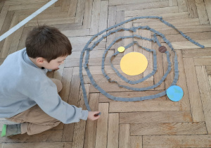 chłopiec układa orbitę po której krży planeta