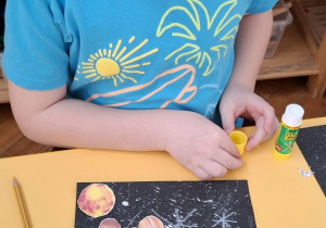 chłopiec przykleja planety