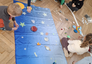 dzieci układają elementy kosmosu