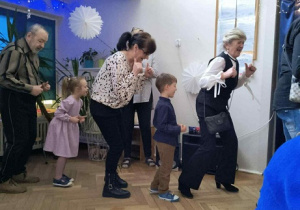 Zdjęcie przedstawia dziadków i dzieci podczas zabawy integracyjnej.