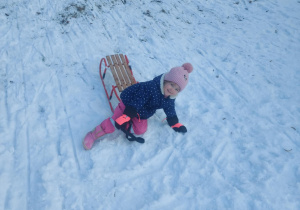 Dziewczynka zjeżdżająca na sankach