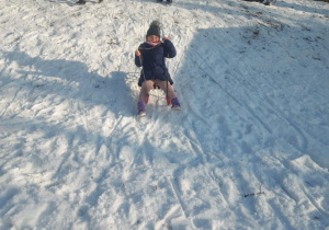 Dziewczynka zjeżdżająca na sankach