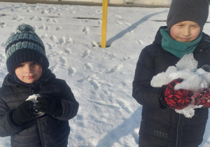 dwoje chłopców ze znalezionymi bryłkami lodu