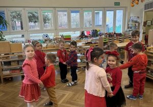 Zdjęcie przedstawia dzieci dobrane w pary, tworzące kółeczka podczas wspólnej zabawy.