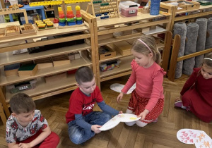 Zdjęcie przedstawia kdziewczynkę wręczającą chłopcu obrazek w kształcie serca.