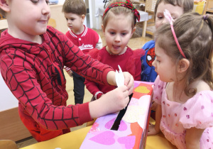 Dzieci wkładają walentynki do poczty