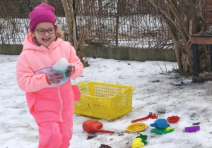 Dziewczynka bawi się śniegiem