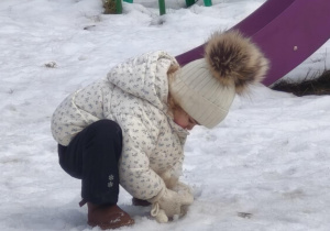 Dziewczynka bawi się śniegiem
