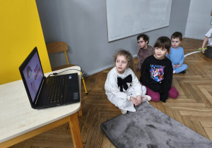 Na zdjęciu widzimy grupkę dzieci, które oglądają film o historii tłustego czwartku.