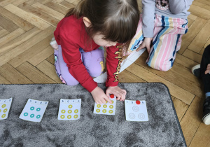 Na zdjęciu widzimy dziewczynkę, która przelicza donaty.