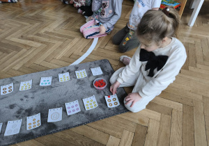 Na zdjęciu widzimy dziewczynkę, która przelicza donaty.