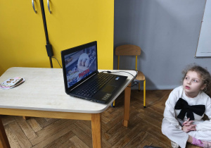 Na zdjęciu widzimy grupkę dzieci, które oglądają film o historii tłustego czwartku.