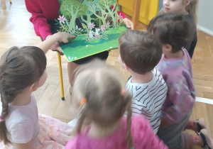 Pani czyta dzieciom bajkę i pokazuje ilustrację.