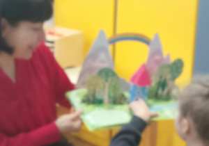 Pani czyta dzieciom bajkę i pokazuje ilustrację.