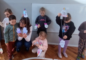 Dzieci stoją z panią i prezentują swoje prace.