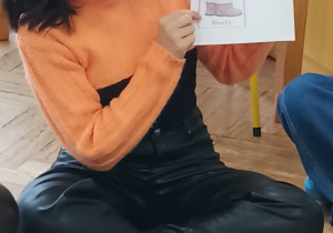 Pani pokazuje ilustrację.