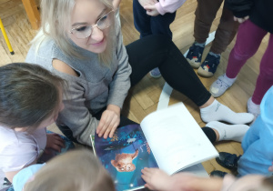 Dzieci oglądają ilustrację w książce.