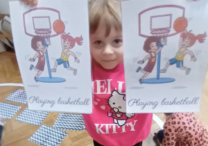 Dziewczynka pokazuje odnalezione pary obrazków.