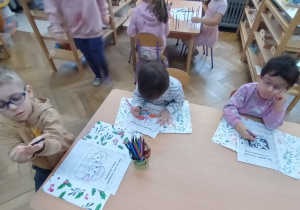 Dzieci kolorują obrazki.