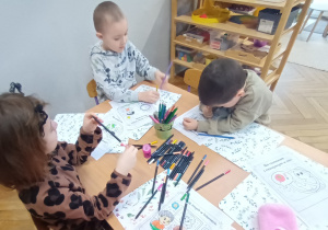 Dzieci kolorują obrazki.