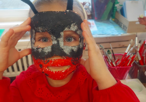 Na zdjęciu dziewczynka ze swoją wykonaną maską