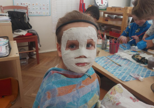 dziewczynka podczas nakładania masy gipsowej