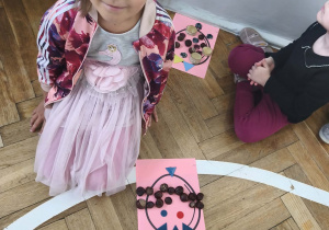 Na zdjęciu widzimy dziewczynkę i jej pracę.