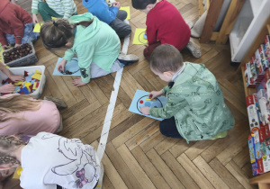 Na zdjęciu widzimy grupkę dzieci, które z wykorzystaniem różnych materiałów rozbudzają swoją kreatywność i tworzą własne balony.