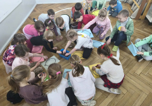 Na zdjęciu widzimy grupkę dzieci, które z wykorzystaniem różnych materiałów rozbudzają swoją kreatywność i tworzą własne balony.