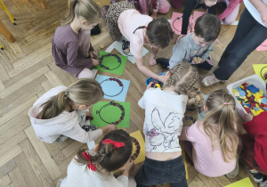 Na zdjęciu widzimy grupkę dzieci, które z wykorzystaniem różnych materiałów rozbudzają swoją kreatywność i tworzą własne balony.