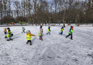 Na zdjęciu widzimy grupkę dzieci bawiących się na śniegu.