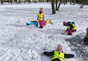 Na zdjęciu widzimy grupkę dzieci bawiących się na śniegu.