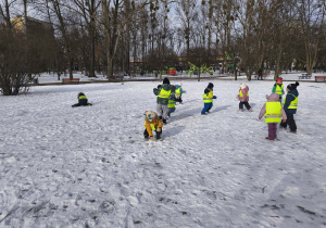 Na zdjęciu widzimy grupkę dzieci bawiących się na śniegu.