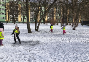 Na zdjęciu widzimy grupkę dzieci bawiących się na śniegu.
